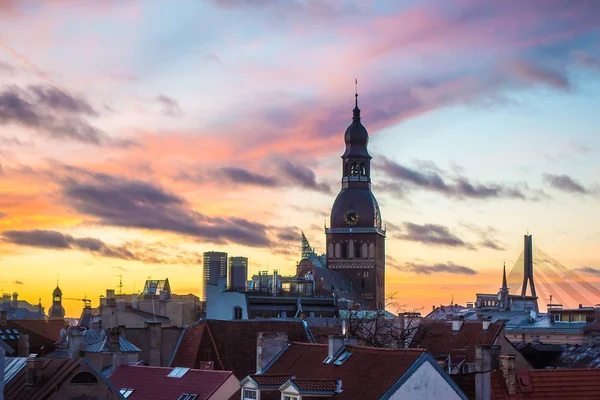 Old Riga střechy a kostel Saint Peters na západ slunce — Stock fotografie