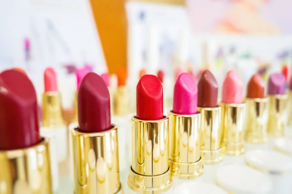 Collection of red and pink lipsticks on light blurred background