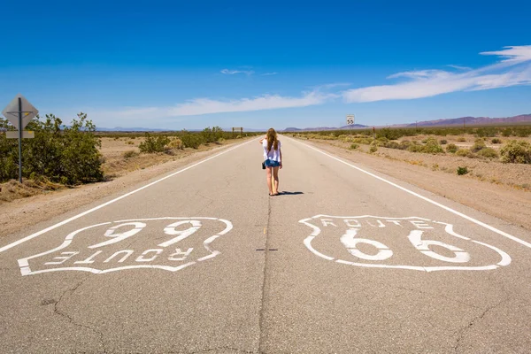 Egy fiatal nő áll a 66-os úton a kaliforniai sivatagban. Egyesült Államok — Stock Fotó