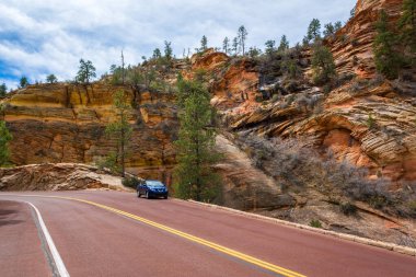Zion Ulusal Parkı 'ndan geçen yol. Kaya tepeleri ve ağaçların manzarası. Utah, Usa