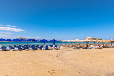Naxos, Yunanistan - 22 Mayıs 2017: Yunanistan 'ın Naxos adasında çok popüler bir tatil beldesi olan Agios Georgios plajında şemsiyeli güneşlikler.