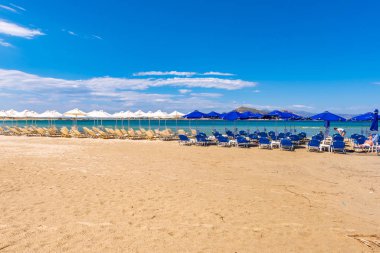 Naxos, Yunanistan - 22 Mayıs 2017: Yunanistan 'ın Naxos adasında çok popüler bir tatil beldesi olan Agios Georgios plajında şemsiyeli güneşlikler.