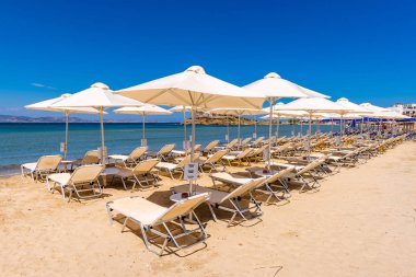 Naxos, Yunanistan - 22 Mayıs 2017: Naxos adasında çok popüler bir tatil beldesi olan Agios Georgios sahilinde şemsiyeli güneşlikler