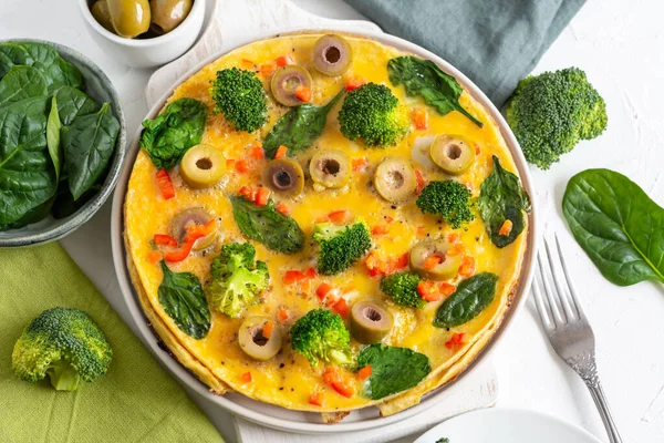 Tortilla con brócoli, espinacas y aceitunas en un plato. Frittata - tortilla italiana con verduras verdes . —  Fotos de Stock