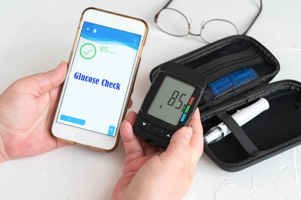 Measuring glucose levels and using smart phone. Healthcare and medical concept — 스톡 사진