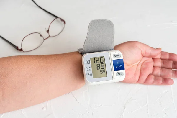 Checking blood pressure with measuring device. Healthcare and medical concept — 스톡 사진