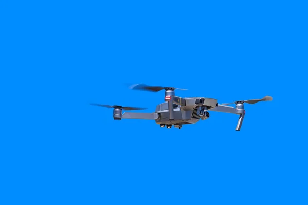 Modern drone with camera flying on a clear blue sky — 스톡 사진