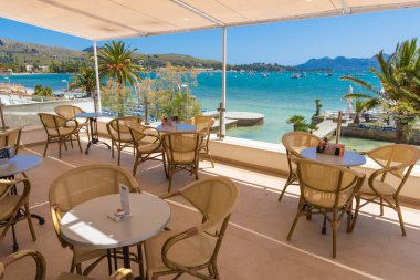 Mallorca, İspanya - 6 Mayıs 2019: Mallorca 'daki Port de Pollenca' da körfeze ve plaja bakan bir restoran