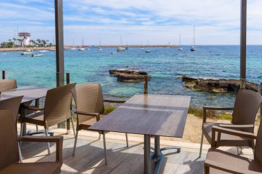 Table and chairs overlooking the bay and Puerto Portals marina resort located on the south-west coast of Majorca. Balearic islands, Spain