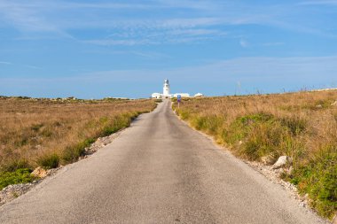 Cavalleria 'nın deniz fenerine giden yol Menorca adasının en kuzeyindeki noktada. Baleares, İspanya