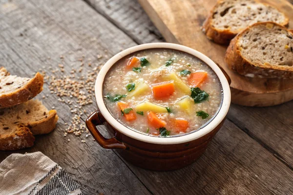 Krupnik, polish barley soup with vegetables on a wooden background