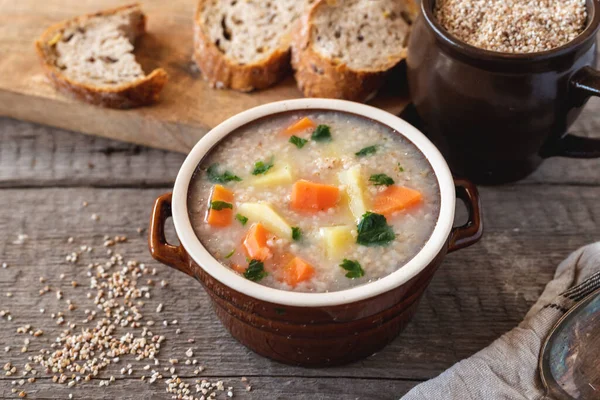 Krupnik, polish barley soup with vegetables on a wooden background