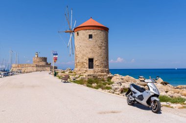 Mandraki 'nin Rodos limanındaki eski yel değirmeniyle deniz kenarında gezinti. Yunanistan