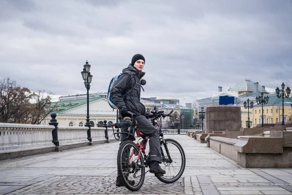 Mladý muž v teplé bundě na kole v centru Moskvy v zimě — Stock fotografie