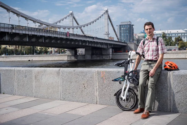 Un giovane con bici pieghevole urbana nel centro di Mosca nella giornata estiva Immagine Stock