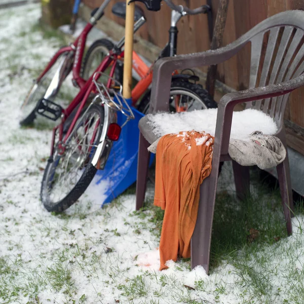 Collection of household objects abandoned under snow, outdoor shot