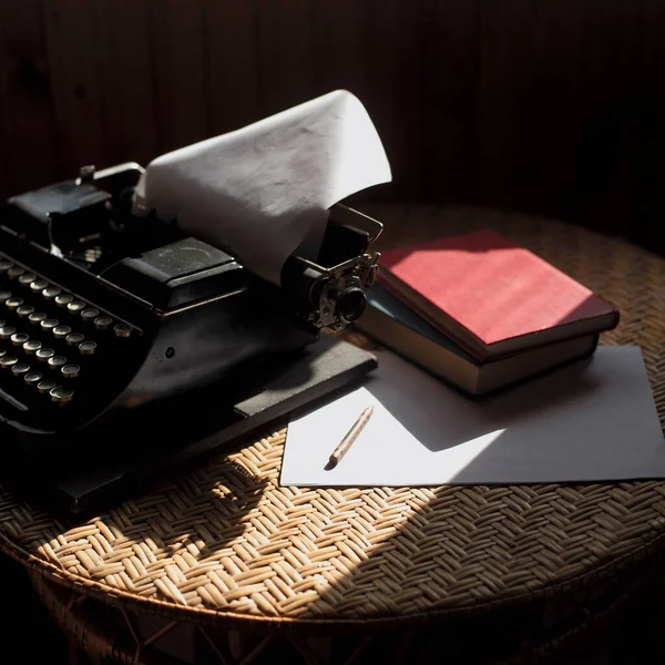 Retro typewriter, books and paper with pen on a table, concept of storytelling