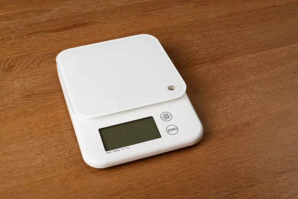 White food scales on a wooden table — Stock Photo, Image