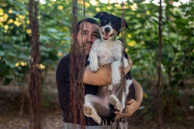 Mutlu köpek sahibine sevgiyle sarılıyor.