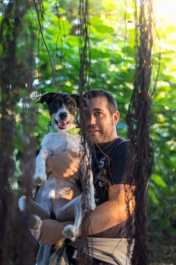 Güzel, mutlu köpek sahibine sevgiyle sarılıyor.