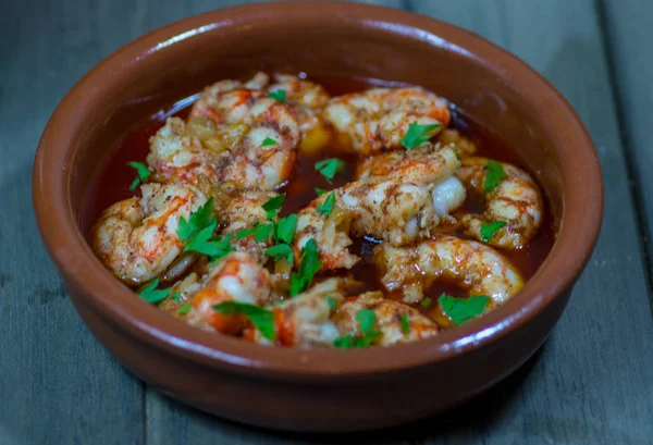 Çamur kavanozunda yağlı sarımsaklı karides.