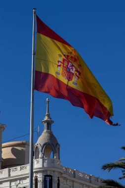 Mavi gökyüzünde dalgalanan İspanya bayrağı