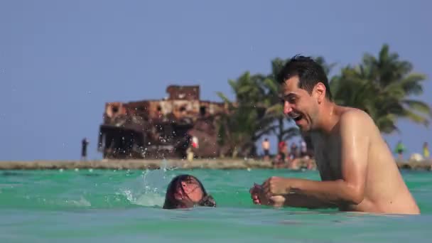 Hombre y mujer se divierten jugando en el agua en las vacaciones de verano — Vídeo de stock