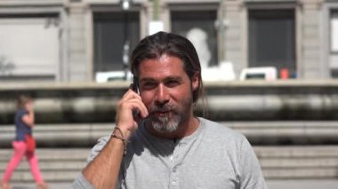 Yürüyüş ve cep telefonundan konuşuyor yakışıklı adam