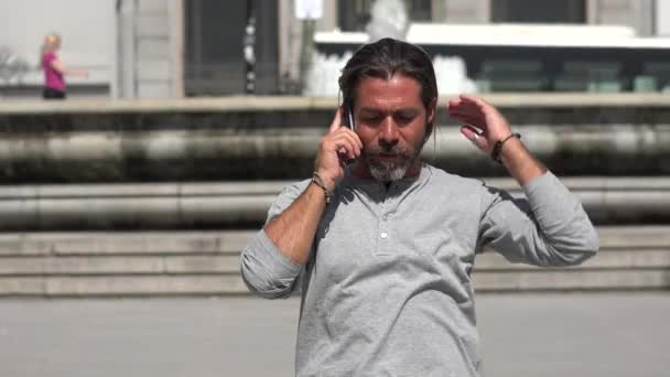 Uomo che cammina mentre parla al telefono — Video Stock