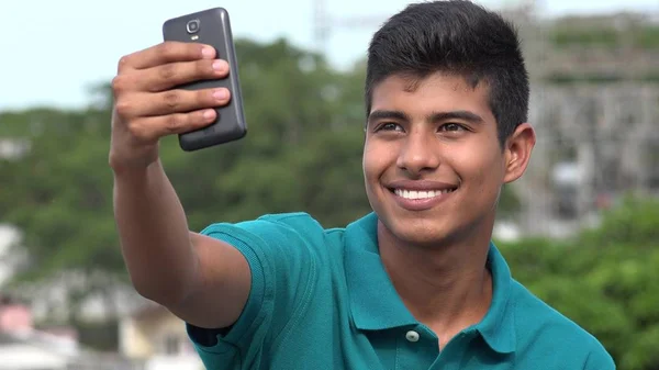 Hymyilevä teini poika ottaa selfyn — kuvapankkivalokuva