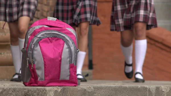 Rosa escuela mochila y niñas usando faldas — Foto de Stock
