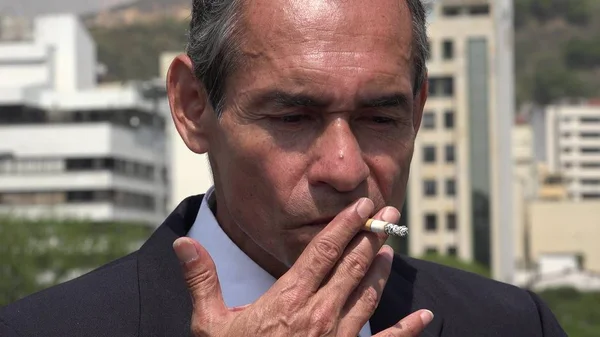 Hombre de negocios hispano mayor fumando — Foto de Stock