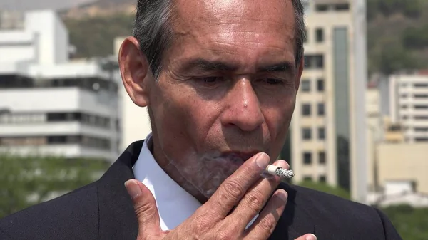 Hombre de negocios hispano mayor fumando — Foto de Stock