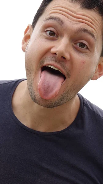 Gracioso caras hombre pegando su lengua fuera — Foto de Stock
