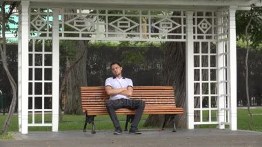 Yalnız adam bankta oturan