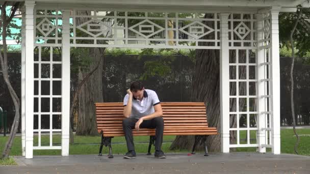 Triste homem deprimido sentado no banco do parque — Vídeo de Stock