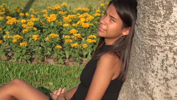 Teenager Mädchen sitzt im Park — Stockvideo