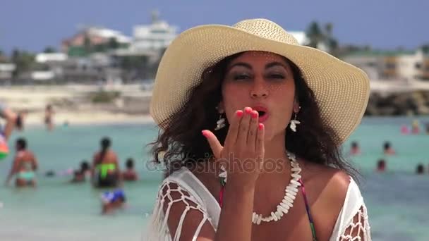 Женщина, дующая в поцелуи и машущая на пляже — стоковое видео