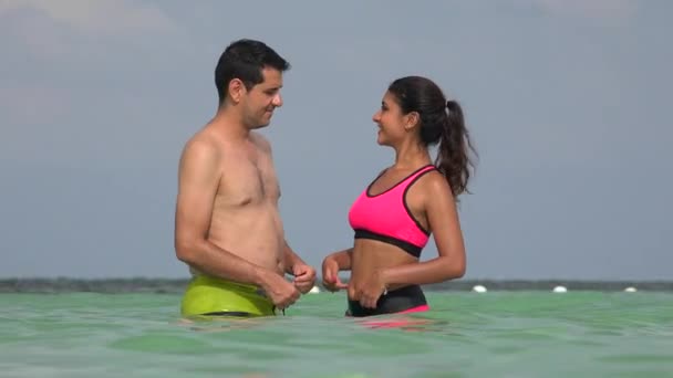 Mannelijke en vrouwelijke paar dragen van badpakken In Oceaan — Stockvideo