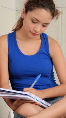 kız öğrencinin not defterinde yazılı