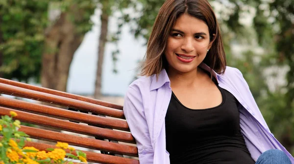 Mujer feliz sentada en el parque —  Fotos de Stock