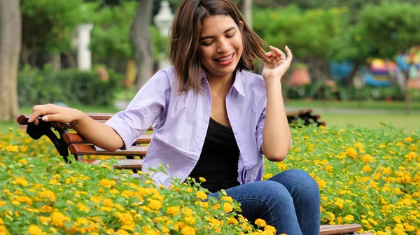 公園に座って笑っているヒスパニック系の女の子 — ストック写真