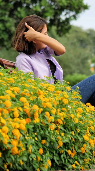 花のそばに座って女の子 — ストック写真