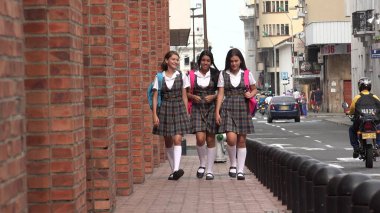 Kaldırımda yürüyen kız öğrenci