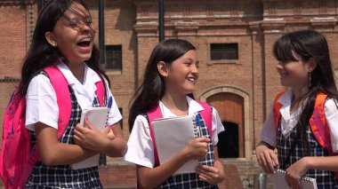 Öğrenciler okul üniformaları giyen gülüyor