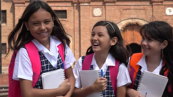 Niñas estudiantes sosteniendo cuadernos usando uniformes escolares —  Fotos de Stock