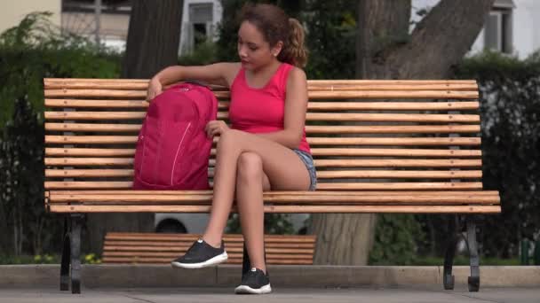 Estudante universitário feminino descansando no banco do parque — Vídeo de Stock