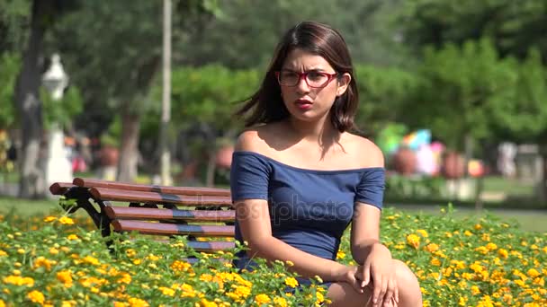 Bonita adolescente chica sentado en parque con mariposa — Vídeo de stock