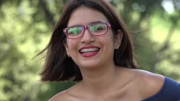 Feliz nerd adolescente chica gafas graduadas y frenos — Vídeo de stock