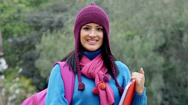 Soğukta kazak giyen kız öğrenci